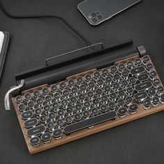 an old fashioned typewriter sitting on top of a table next to a cell phone