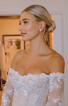 a woman in a wedding dress looking off to the side with her hand on her hip