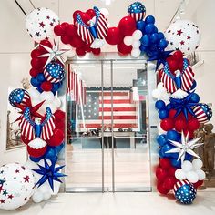 an american flag balloon arch with stars and stripes on the front entrance to a building