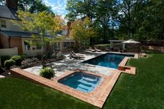 a backyard with a swimming pool surrounded by lush green grass