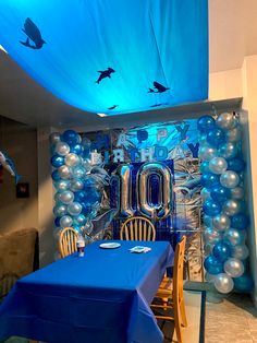 a room with balloons and blue table cloths on the walls, along with an ocean theme