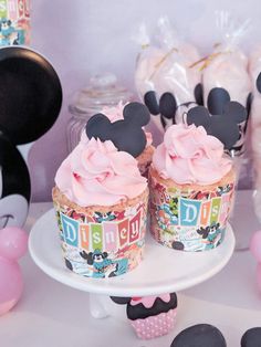 some cupcakes with pink frosting and mickey mouse ears