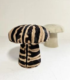 a zebra print object sitting on top of a white table next to a mushroom shaped object