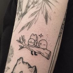 a person with a tattoo on their arm has a cat and dog sleeping on a tree branch