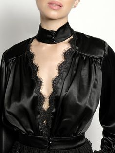 Our Rita Blouse in black features a plunging V neckline trimmed with delicate Venise lace, a true waistline cinch and soft billowing sleeves all trimmed with Alençon lace and embroidered ruffled tulle lace. 100% Silk Charmeuse lined with Silk Habutai Three satin covered pearl buttons for each closure Dry clean only Each piece is made to order and handcrafted in our atelier. Slight variations may occur as each piece is unique. Luxury Long Sleeve Tops With Lace Trim, Chic V-neck Blouse With Lace Collar, Elegant V-neck Blouse With Lace Sleeves, Elegant V-neck Blouse With Lace Collar, Formal V-neck Tops With Lace Trim, V-neck Lace Blouse With Lace Collar, Elegant Black Blouse With Lace Cuffs, Lace V-neck Top For Evening, Lace V-neck Evening Top