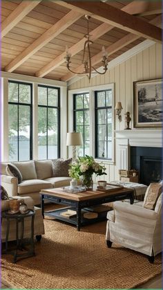 a living room with couches, chairs and a coffee table in front of two windows