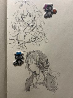 two anime characters are drawn on paper with buttons attached to the back of each character