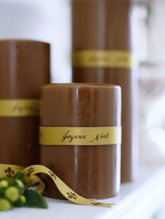 three chocolate candles are sitting on a table next to some grapes and flowers with a yellow ribbon around them