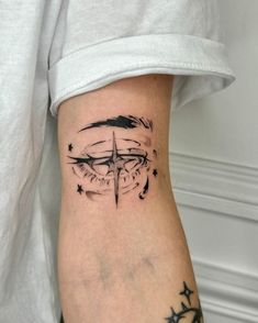 a woman's arm with a compass tattoo on the left side of her leg