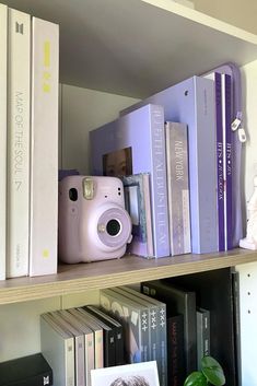 a camera and some books on a shelf