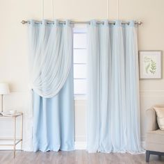 a living room with white walls and blue curtains