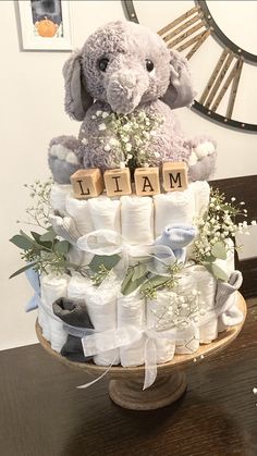 a stuffed animal sitting on top of a pile of diapers next to a clock