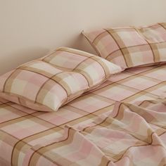 a bed with pink and brown checkered sheets