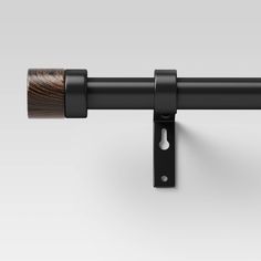 a close up of a black curtain rod with a wooden handle on it's end