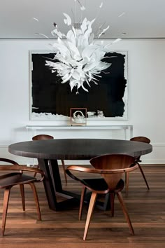 a dining room table with chairs and a chandelier hanging from it's ceiling