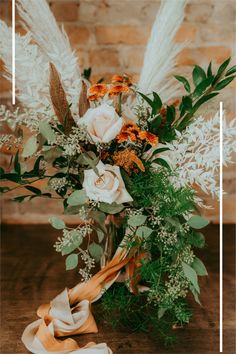 a vase filled with flowers and greenery on top of a wooden table