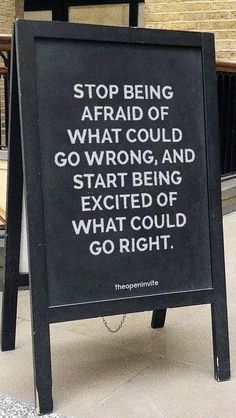 a sign that is sitting on the ground in front of a building saying stop being afraid of what could go wrong and start being excited of what could go right