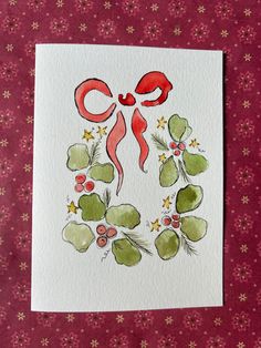 a card with the letter c in red and green leaves, flowers, and berries