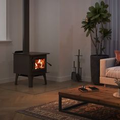 a living room with a couch, coffee table and a wood burning stove in it