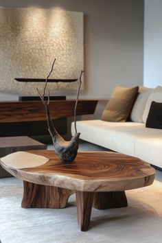 a living room with white couches and a wooden coffee table in the shape of a bird