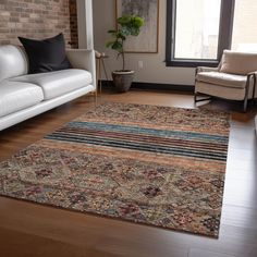 a living room filled with furniture and a large rug on top of a hard wood floor