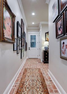 a hallway with pictures on the wall and an area rug