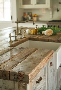 a kitchen counter made out of wooden planks with white cabinets and drawers in the background