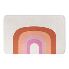 a bath mat with an orange, pink and white rainbow design