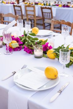 the table is set with plates, silverware and lemons for an elegant dinner