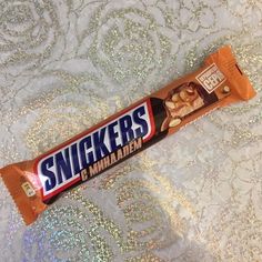 a bar of snickkers is sitting on a tablecloth with silver sequins