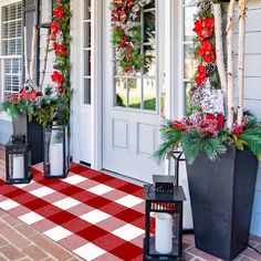 christmas decorations on the front door of a house with red and white checkered rug