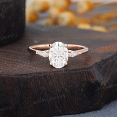 a white diamond ring sitting on top of a wooden table