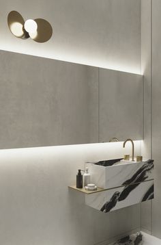 a bathroom with a sink, mirror and lights on the wall above it's counter