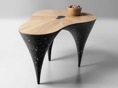 a wooden table with black legs and a bowl on top