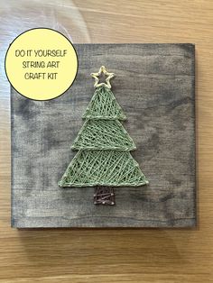 a string art christmas tree on a wooden board with a thought bubble above it that says do it yourself string art craft kit