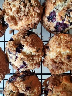 blueberry muffins on a cooling rack with crumbs all over them