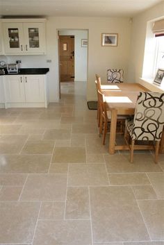 a dining room table and chairs in a kitchen with tile flooring on the floor