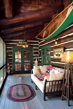 the inside of a log cabin with wood floors and green trimmings on the walls