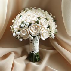 a bridal bouquet with white roses and baby's breath on a satin background