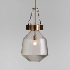 a clear glass light fixture hanging from a metal ceiling lamp with a chain attached to it