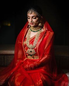 a woman in red and gold is sitting down