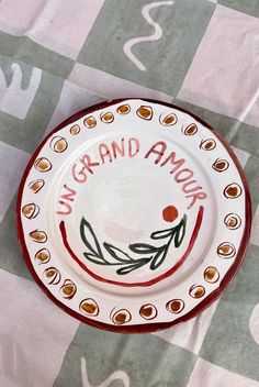 a red and white plate sitting on top of a checkered table cloth