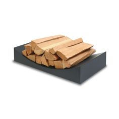 a pile of wood sitting on top of a black platform next to a white wall