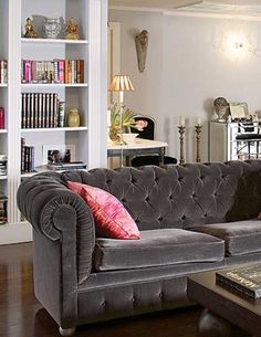 a living room filled with furniture and bookshelves