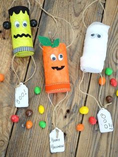 three halloween candy bags with faces and noses on them, hanging from twine strings