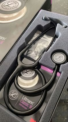 a pair of scissors sitting inside of a black box on top of a table next to other items