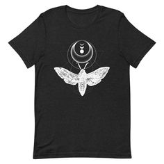 The moth represents optimism, always seeking light in the darkness. This insect t-shirt makes the perfect gift for a nature lover! It features my original graphic design work using a vintage moth sketch.  This lightweight t-shirt is soft and just the right amount of stretch. It's flattering and comfortable for both men and women. My t-shirts are designed by me and made/shipped by my production partner. Size guide: Length (inches) S: 28 M: 29 L: 30 XL: 31 2XL: 32 3XL: 33 4XL: 34 Width (inches) S: 18 M: 20 L: 22 XL: 24 2XL: 26 3XL: 28 4XL: 30 SHIPPING LOCATIONS I work with a production partner to have my artwork made-to-order on t-shirts, prints, and more. When you place an order it will be sent to one of their fulfillment centers dependent on product type, availability, and shipping locatio Moth Sketch, Witchy Tshirt, Wiccan Shirt, The Tower Tarot Card, Graphic Design Work, Light In The Darkness, The Moth, Boho Cottage, Butterfly Shirts