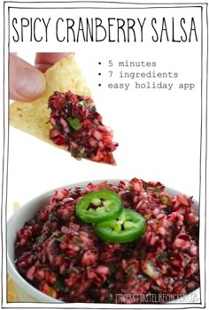 the recipe for spicy cranberry salsa is shown in a bowl with a tortilla chip