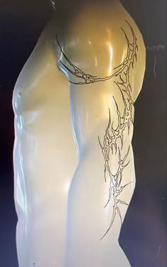 a white mannequin with an intricate design on it's back and arms