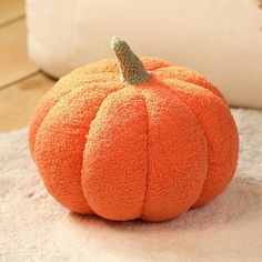 an orange pumpkin sitting on top of a white rug